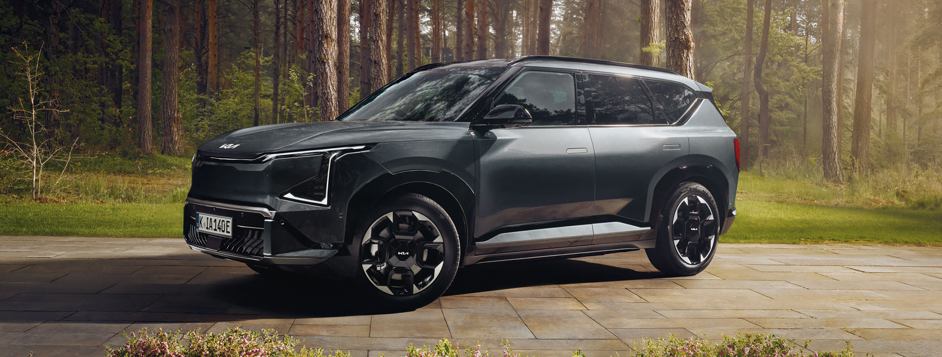 Kia EV5 vor einem Waldgebiet